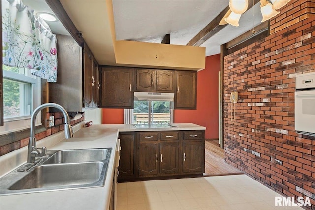 5016 Kinsinger Ln, Pleasant Plains, IL 62677 - kitchen with white oven, brick wall, dark brown cabinetry, light floors, and light countertops