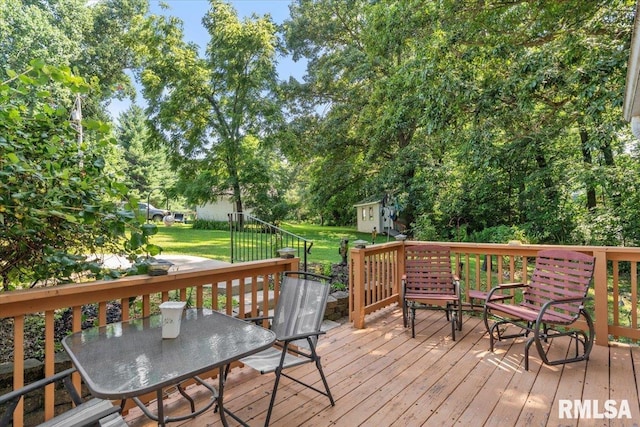 7971 Mechanicsburg Rd, Springfield, IL 62707 - deck with outdoor dining area, a lawn, an outdoor structure, and view of wooded area