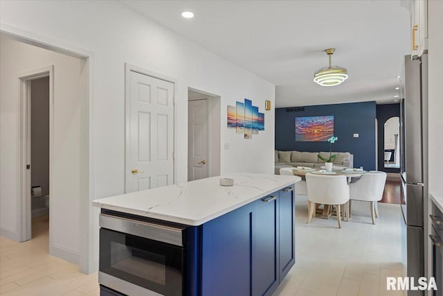 345 Country Towne Rd, Springfield, IL 62712 - kitchen with blue cabinetry, stainless steel appliances, light stone countertops, a kitchen island, and hanging light fixtures