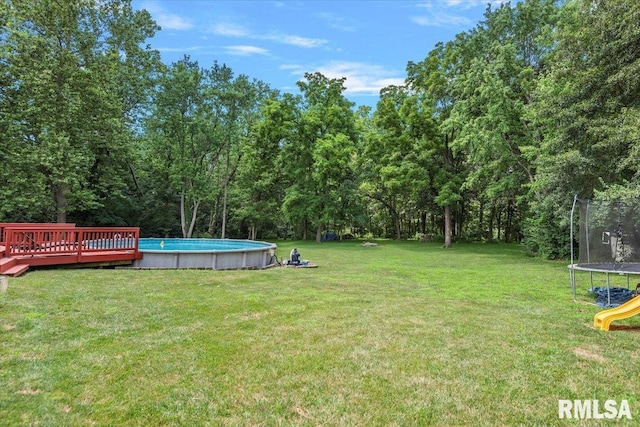 345 Country Towne Rd, Springfield, IL 62712 - view of grassy yard with a trampoline, an outdoor pool, and a deck