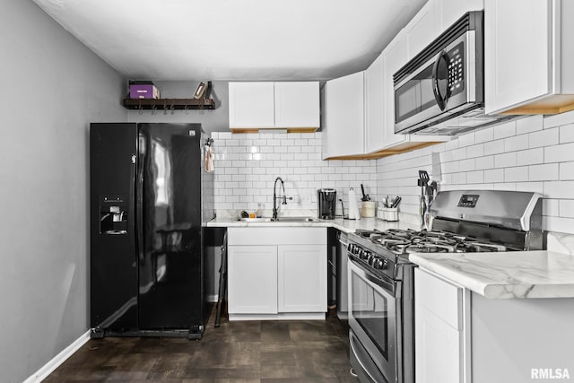 2208 E Black Ave, Springfield, IL 62702 - kitchen with stainless steel appliances, tasteful backsplash, white cabinetry, and light stone counters