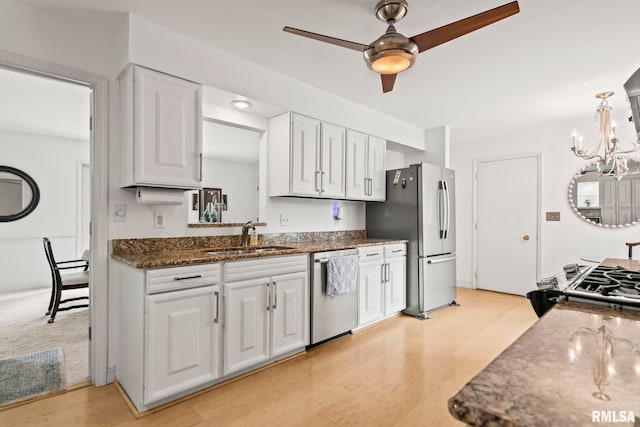 1613 Denison Dr, Springfield, IL 62704 - kitchen with stainless steel appliances, white cabinetry, ceiling fan, a chandelier, and dark stone counters