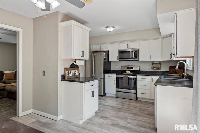 84 Chukar Dr, Chatham, IL 62629 - kitchen with appliances with stainless steel finishes, dark countertops, white cabinetry, and ceiling fan