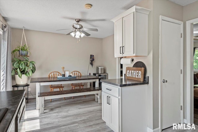 84 Chukar Dr, Chatham, IL 62629 - kitchen featuring ceiling fan, dark countertops, light wood finished floors, white cabinetry, and a textured ceiling