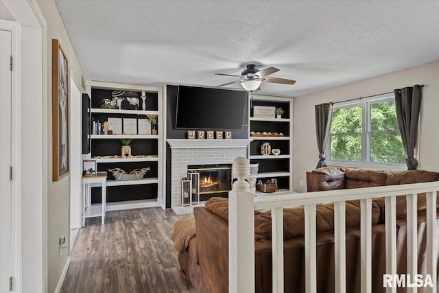 84 Chukar Dr, Chatham, IL 62629 - living area with a textured ceiling, a ceiling fan, wood finished floors, a brick fireplace, and built in shelves