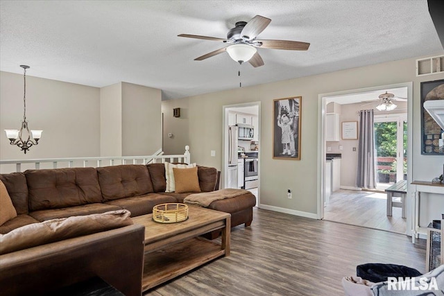84 Chukar Dr, Chatham, IL 62629 - living area featuring a ceiling fan, wood finished floors, a chandelier, and a textured ceiling
