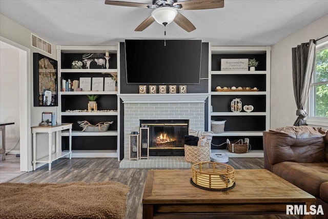 84 Chukar Dr, Chatham, IL 62629 - living area featuring a ceiling fan, wood finished floors, a textured ceiling, built in shelves, and a fireplace