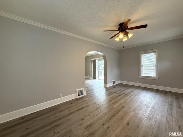 833 Willard St, Galesburg, IL 61401 - empty room with arched walkways, ceiling fan, plenty of natural light, dark wood-style floors, and crown molding