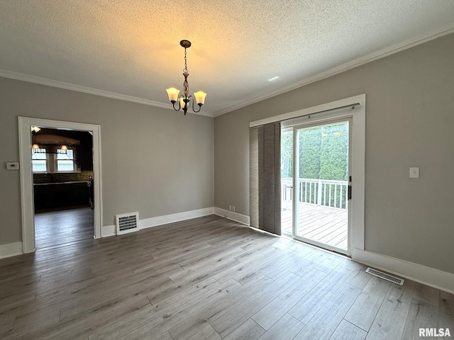 833 Willard St, Galesburg, IL 61401 - empty room with a chandelier, healthy amount of natural light, ornamental molding, a textured ceiling, and wood finished floors