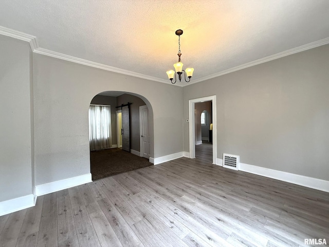 833 Willard St, Galesburg, IL 61401 - empty room featuring arched walkways, a chandelier, wood finished floors, crown molding, and a textured ceiling