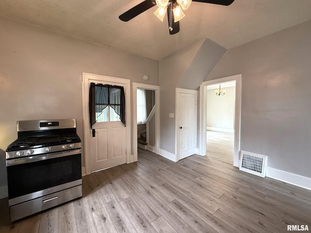 833 Willard St, Galesburg, IL 61401 - kitchen with stainless steel range with gas cooktop, ceiling fan, wood finished floors, a chandelier, and lofted ceiling