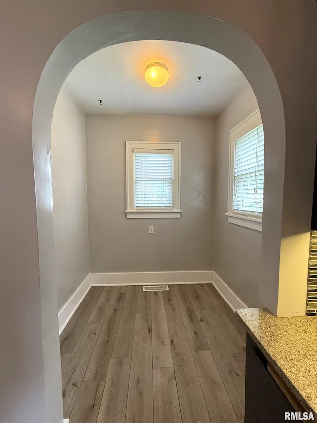 833 Willard St, Galesburg, IL 61401 - unfurnished dining area with arched walkways, plenty of natural light, and wood finished floors