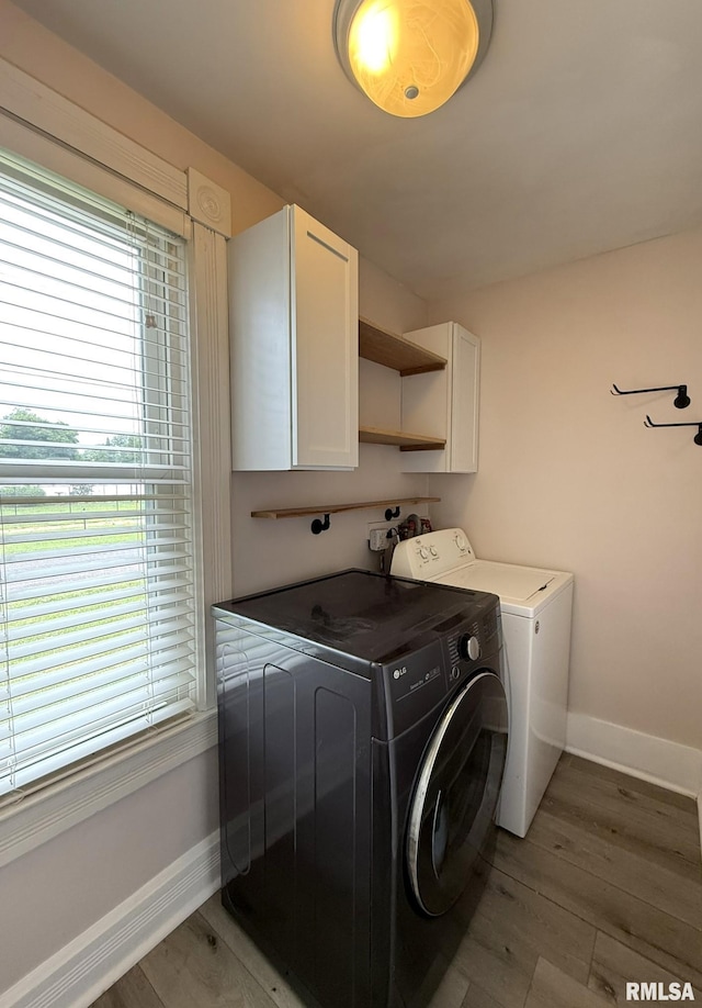 833 Willard St, Galesburg, IL 61401 - laundry room featuring cabinet space, independent washer and dryer, light wood-style flooring, and healthy amount of natural light