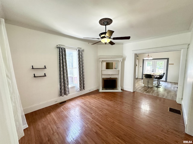 231 N Webster Ave, Jacksonville, IL 62650 - unfurnished living room featuring wood finished floors, ceiling fan, and a fireplace with flush hearth