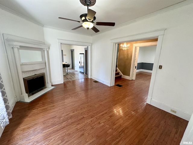 231 N Webster Ave, Jacksonville, IL 62650 - unfurnished living room featuring a fireplace with flush hearth, wood finished floors, stairway, and ceiling fan