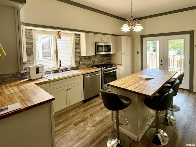 231 N Webster Ave, Jacksonville, IL 62650 - kitchen featuring wooden counters, stainless steel appliances, french doors, decorative backsplash, and ornamental molding