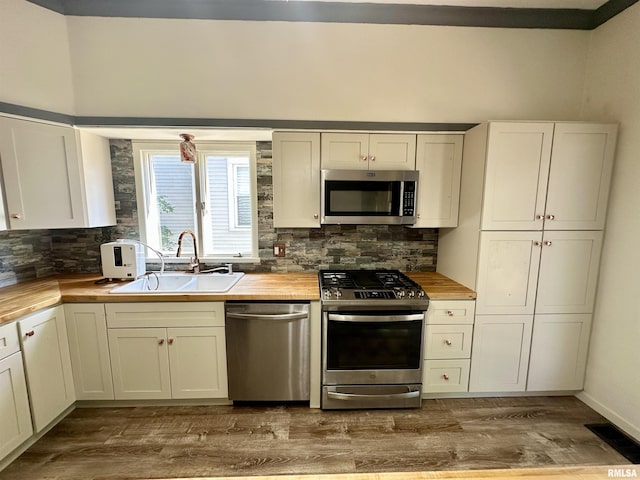 231 N Webster Ave, Jacksonville, IL 62650 - kitchen with appliances with stainless steel finishes, wood counters, wood finished floors, and decorative backsplash