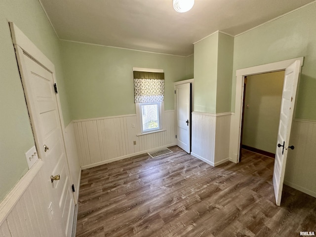 231 N Webster Ave, Jacksonville, IL 62650 - unfurnished bedroom with a wainscoted wall and wood finished floors