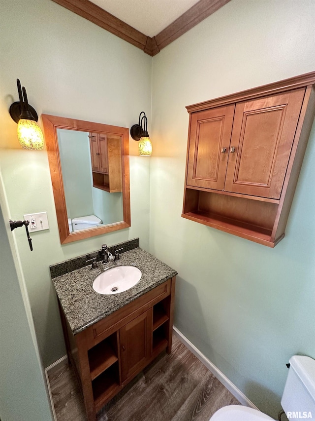 231 N Webster Ave, Jacksonville, IL 62650 - half bathroom with wood finished floors, vanity, and ornamental molding