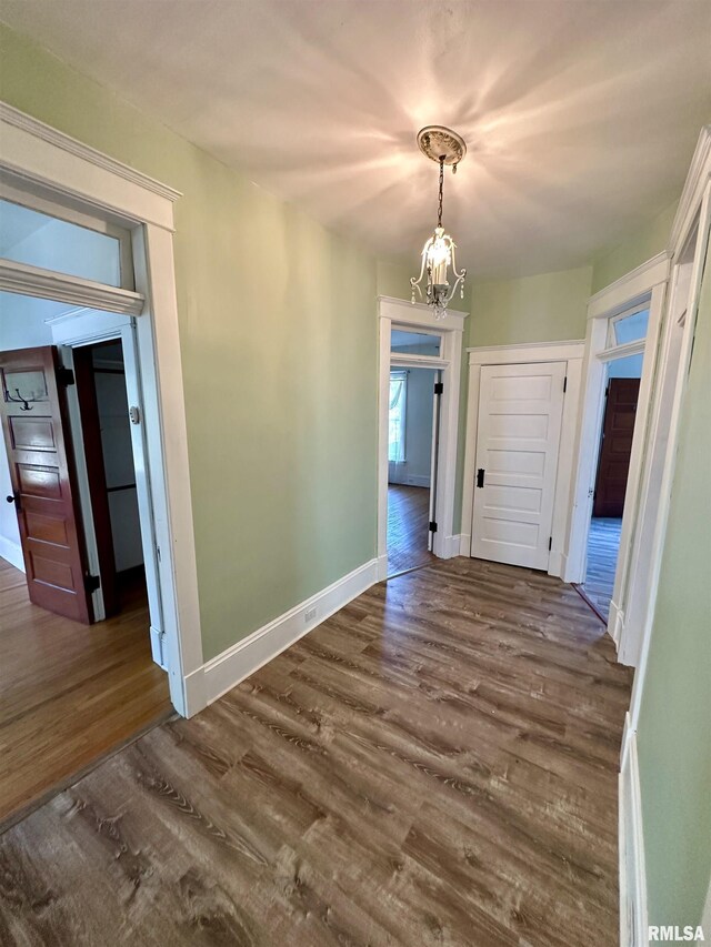 231 N Webster Ave, Jacksonville, IL 62650 - unfurnished dining area featuring dark wood-type flooring and a chandelier