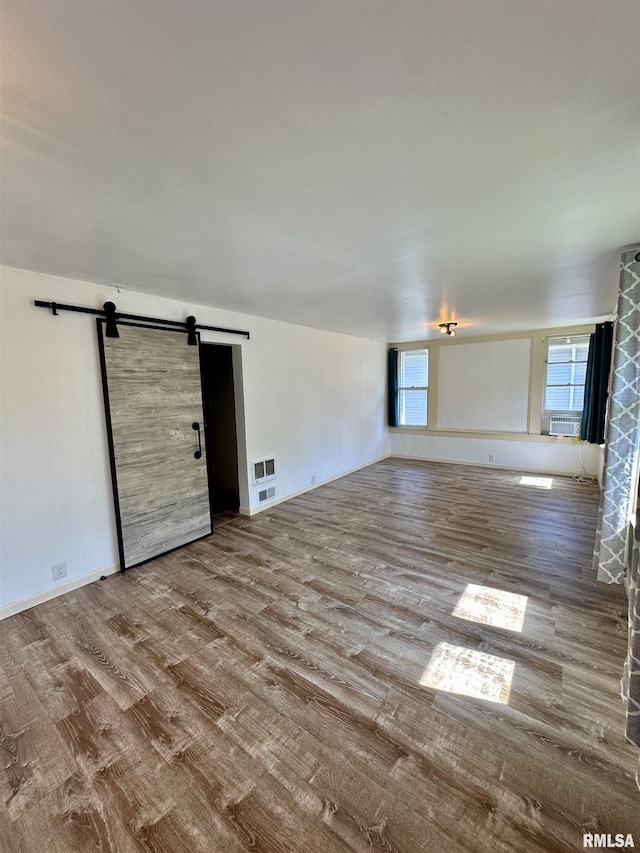 231 N Webster Ave, Jacksonville, IL 62650 - unfurnished room featuring wood finished floors, a barn door, and cooling unit