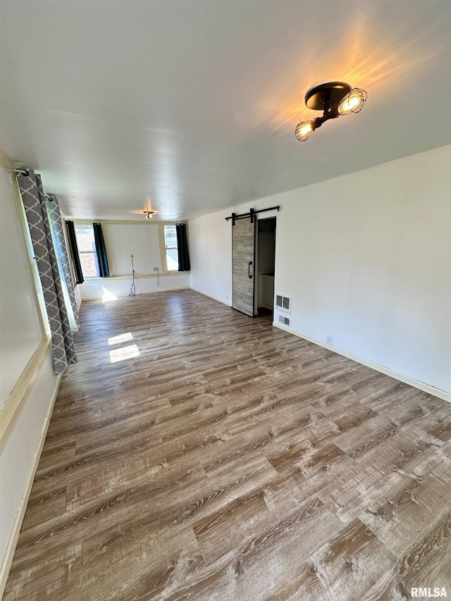 231 N Webster Ave, Jacksonville, IL 62650 - unfurnished living room featuring wood finished floors and a barn door