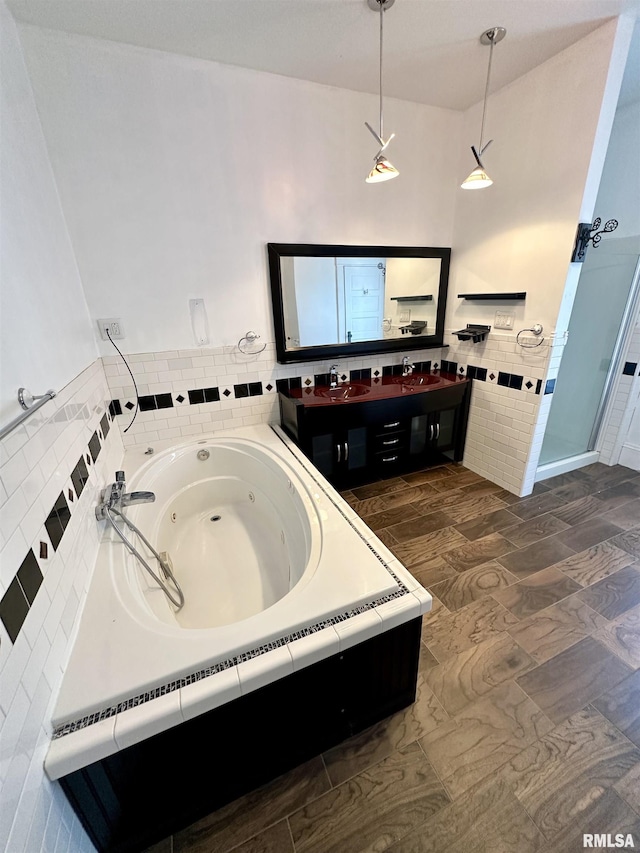 231 N Webster Ave, Jacksonville, IL 62650 - bathroom with double vanity, a tub with jets, tile walls, wood finished floors, and a shower