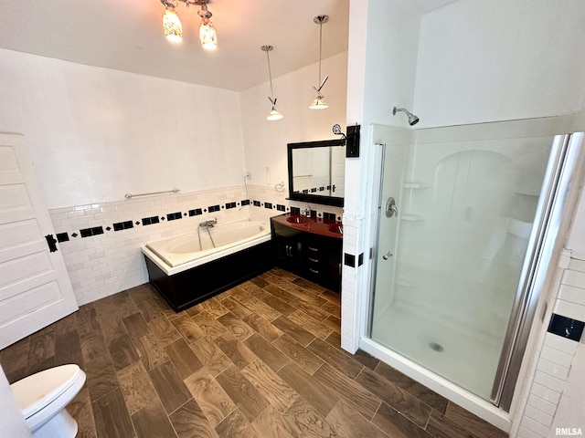 231 N Webster Ave, Jacksonville, IL 62650 - bathroom featuring a shower stall, a garden tub, vanity, tile walls, and wood finished floors