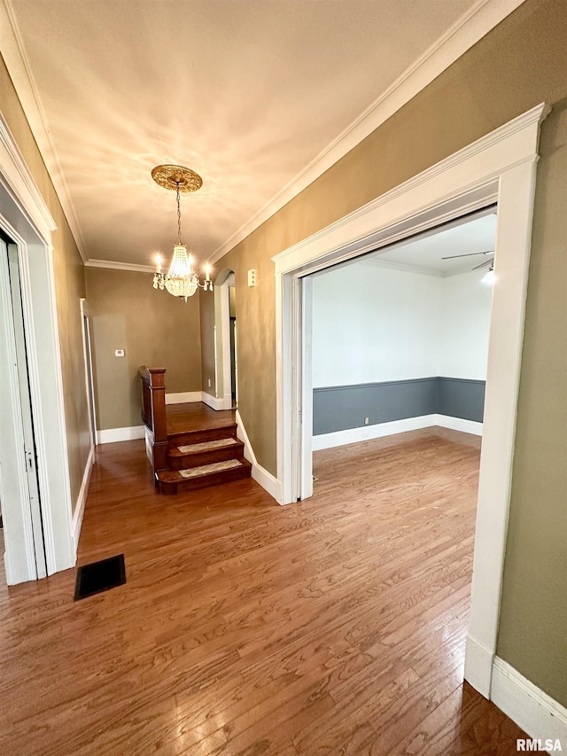 231 N Webster Ave, Jacksonville, IL 62650 - spare room with wood finished floors, a chandelier, ornamental molding, and stairway