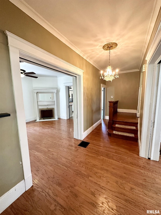 231 N Webster Ave, Jacksonville, IL 62650 - unfurnished dining area with a chandelier, crown molding, wood finished floors, a fireplace, and stairs