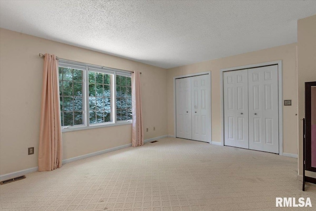 1009 Rickard Ct, Springfield, IL 62704 - unfurnished bedroom with carpet flooring, two closets, and a textured ceiling