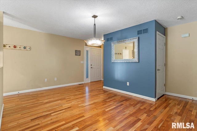 1009 Rickard Ct, Springfield, IL 62704 - unfurnished room featuring light wood-style floors, a textured ceiling, and a smoke detector