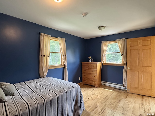 778 E Grove St, Galesburg, IL 61401 - bedroom with a baseboard heating unit, multiple windows, and light wood-style floors