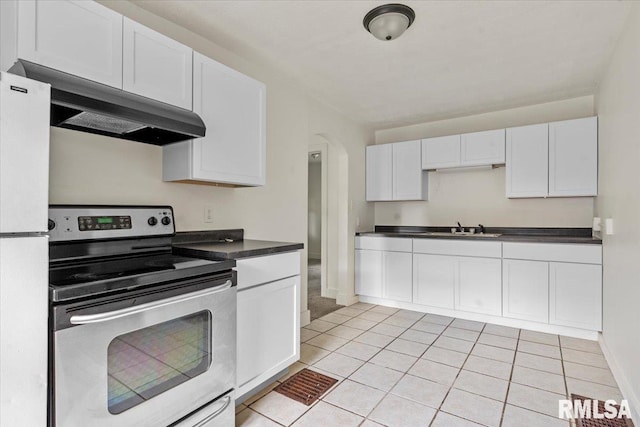 1310 Ledlie Ave, Springfield, IL 62702 - kitchen with stainless steel electric range, extractor fan, freestanding refrigerator, dark countertops, and white cabinets