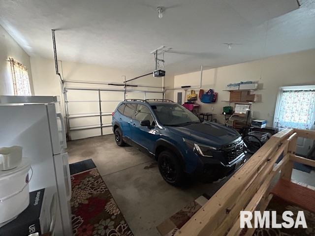 4424 Venetian Dr, Springfield, IL 62703 - garage featuring a garage door opener and freestanding refrigerator