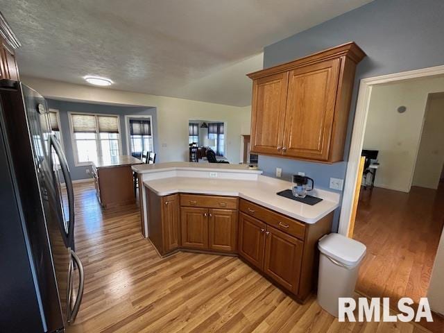 4424 Venetian Dr, Springfield, IL 62703 - kitchen featuring freestanding refrigerator, a peninsula, light wood-style flooring, and brown cabinets
