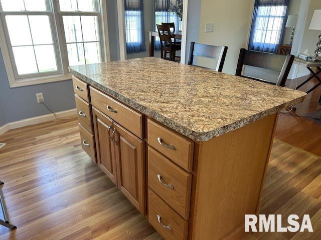 4424 Venetian Dr, Springfield, IL 62703 - kitchen featuring light wood-style floors, a center island, brown cabinetry, and light stone countertops
