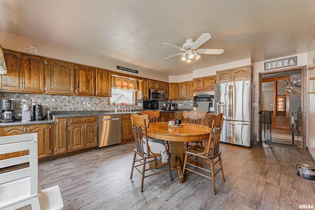 209 N 2nd St N, Easton, IL 62633 - kitchen with appliances with stainless steel finishes, a ceiling fan, light wood-type flooring, and tasteful backsplash