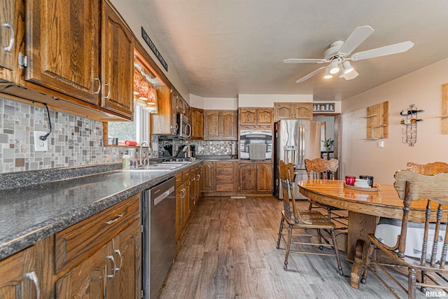 209 N 2nd St N, Easton, IL 62633 - kitchen with stainless steel appliances, a ceiling fan, wood finished floors, brown cabinetry, and tasteful backsplash
