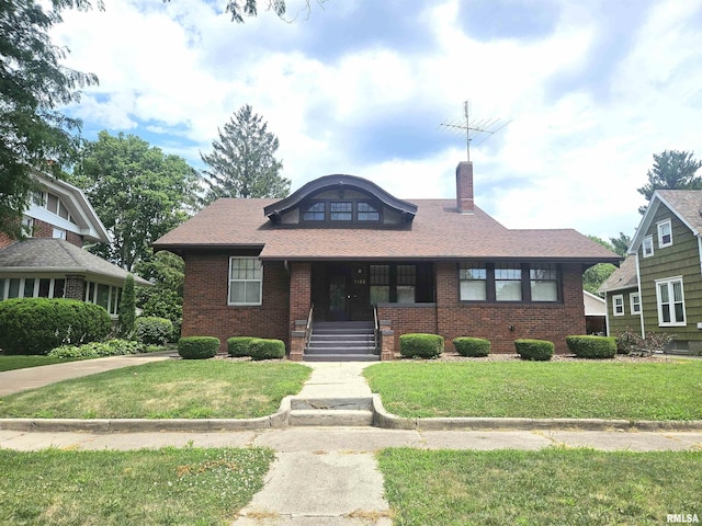 1155 N Cherry St, Galesburg, IL 61401 - view of front of house featuring brick siding, a chimney, and a front yard