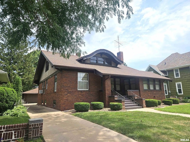 1155 N Cherry St, Galesburg, IL 61401 - view of front of house with brick siding, a front lawn, a chimney, and a detached garage