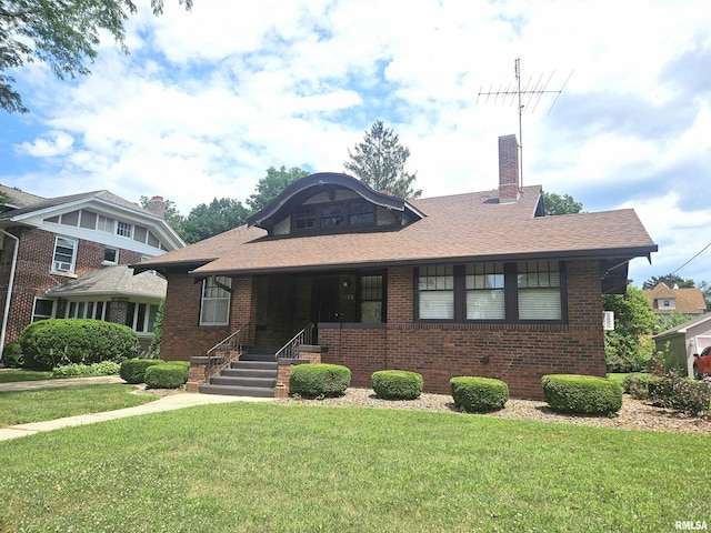 1155 N Cherry St, Galesburg, IL 61401 - view of front of home with a front yard, brick siding, a chimney, and a shingled roof