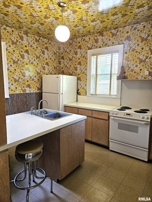 1155 N Cherry St, Galesburg, IL 61401 - kitchen with white appliances, wallpapered walls, wainscoting, light countertops, and decorative light fixtures