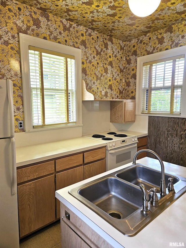1155 N Cherry St, Galesburg, IL 61401 - kitchen with white appliances, wallpapered walls, plenty of natural light, and light countertops