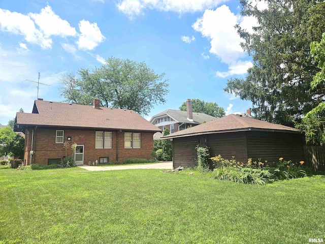1155 N Cherry St, Galesburg, IL 61401 - rear view of property featuring a lawn, brick siding, and driveway