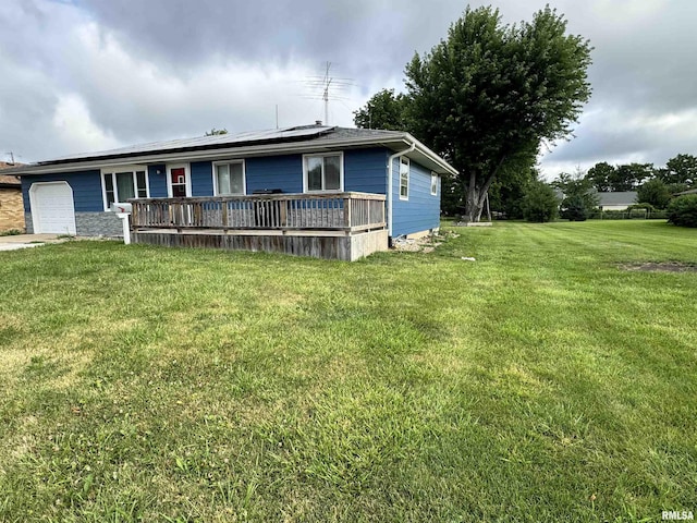 1275 Sunview Dr, Canton, IL 61520 - view of front of home featuring a garage, solar panels, a front yard, concrete driveway, and a wooden deck