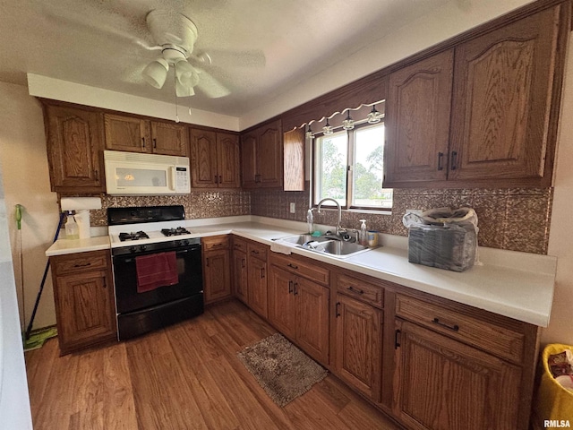 1275 Sunview Dr, Canton, IL 61520 - kitchen with white microwave, range with gas cooktop, light wood-type flooring, decorative backsplash, and light countertops