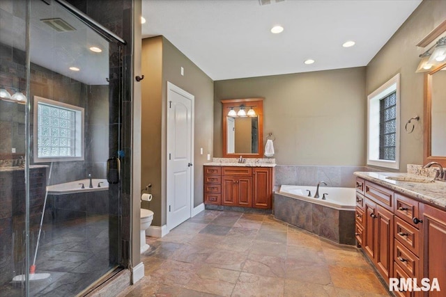 4408 Foxhall Ln, Springfield, IL 62711 - full bathroom with two vanities, a garden tub, stone tile flooring, a shower stall, and recessed lighting