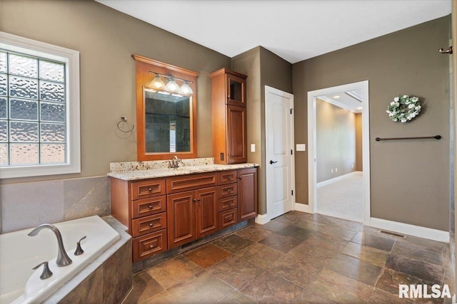 4408 Foxhall Ln, Springfield, IL 62711 - bathroom with stone tile flooring, vanity, a garden tub, and healthy amount of natural light