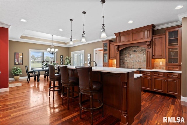 4408 Foxhall Ln, Springfield, IL 62711 - kitchen featuring light countertops, a chandelier, ornamental molding, tasteful backsplash, and a center island with sink